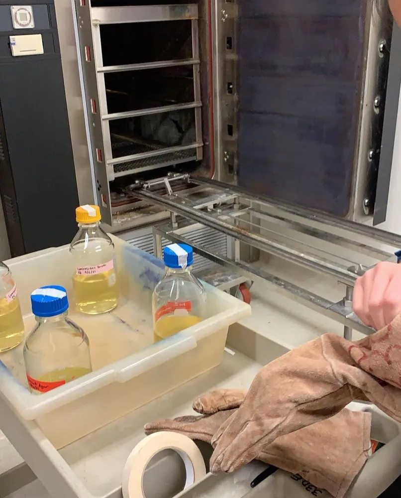 Media bottles beside a lab autoclave